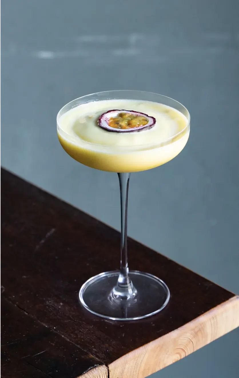 Cocktail med passionsfrugt serveret i coupeglas